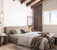 Spacious bedroom with wooden beams on the ceiling, large windows providing natural light, a plush gray bed with bedding, side tables, and a pendant light fixture.