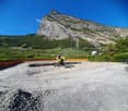 Empty construction site, gravel, machinery in the center, vineyard at the back, mountain at the far back