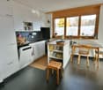 modern kitchen with wooden countertops, white cabinetry, and black tile flooring