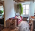 living room with wooden floor, couch, table, window, skull figure, boxes