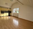 empty kitchen with wooden floor, yellow cabinets, white walls, window, radiator