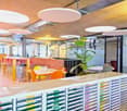 modern interior with large open space, desks, chairs, and a large plant