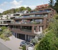 Modern multi-story house with balconies, garage, and raised ground floor