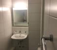 Tiled bathroom with a sink, mirror, and shower stall