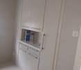 modern white built-in cabinets, white floor, power outlet on the wall