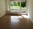 large windows, balcony with railings, wooden floor, white walls, central heating