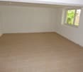 Empty room with white walls, tiled flooring, a single window