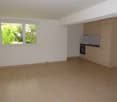 empty room, tile flooring, white walls, large window, kitchen with cabinets and oven