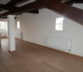 empty room, wooden floors, white walls, wooden beams, two windows, two radiators