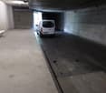 underground parking space, white van, white bench, concrete walls