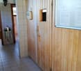 Tiled floor, wooden paneled walls, storage cabinets, and a washing machine visible