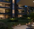 3 story apartment building with balconies, exterior seating area with tables and plants, outdoor garden, and evening lighting