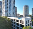 Multi-story commercial building with glass windows, the building has the 'Citypop' logo on the facade, surrounded by other high-rise buildings and trees