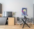 modern interior, flat screen TV, black table, 2 grey chairs, black cabinet with shelves, light colored flooring, painting on the wall