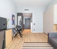 open-plan living space, wooden floor, modern furniture, table, dining chairs, couch, flat-screen TV, dining area with a table and chairs