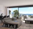 Spacious living room with large windows offering a scenic view of the surrounding landscape. The room features a comfortable gray sofa, a wooden coffee table, and a dining area with a black table and chairs. The room is decorated with potted plants and a