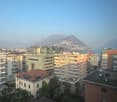 Cityscape with high-rise buildings, residential apartments, and a mountain in the background.