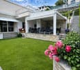 modern house, large terrace, outdoor seating, garden, brick wall, flowers