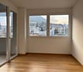 empty room with wooden floor, white walls, large windows with balcony access, mountain view