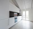 modern kitchen, white cabinets, tiled floor, stainless steel appliances, large windows