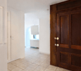 empty hallway with ceiling lights, wooden door, tiled floor, hallway leading to rooms