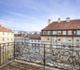 Balcony with wooden floor, wrought iron railing, overlooking the street and buildings