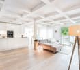 open plan living room and kitchen, white cabinets, wooden floor, large windows, balcony, modern decor