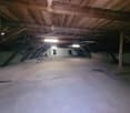 empty room, wooden ceiling, metal beams, concrete floor, small chair, two windows