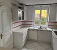 modern kitchen with white cabinets, tiled floor, stainless steel sink, dishwasher, electric stove