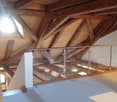 Wooden beams and trusses, exposed wooden structure, open space with natural lighting from a window