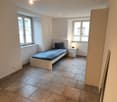 Empty room with bed, nightstand, and two windows