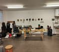 Empty room with desk, masks on wall, items scattered, and a water heater.
