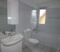 Bathroom with sink, toilet, bathtub, mirror, cabinet, and tiles
