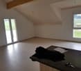 Empty room with large windows and sliding doors, offering a scenic view.