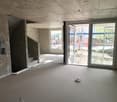 Empty room, concrete floor, unfinished walls, stairs, sliding glass doors, balcony