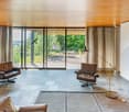 Two leather armchairs, wooden ceiling, tiled floor, large glass sliding doors to balcony, floor lamp