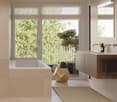 Bathroom with bathtub, sink, mirror, balcony, and window with view of the trees.