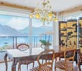 a wooden table, 4 chairs, a wooden screen, a chandelier, a flower vase, balcony