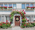 white house, wooden door, red flowers, window boxes, cobblestone path