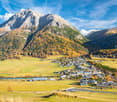 Mountainous landscape with alpine village and green meadow