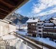 Balcony, tables and chairs, snowy landscape, mountains in the background