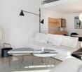 Modern living room with white couch, fireplace, floor lamps, center tables, round dining table and chairs