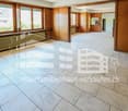 empty room with white tiles, wooden panels, windows, and under-window radiators