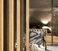 large wooden panel on the wall, modern design, glass door leading to a terrace, white interior