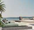 furnished outdoor balcony with lounge chairs, coffee table, view of ocean