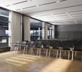 Modern meeting room with rows of black chairs, wooden floor, large windows with views of a cityscape, retractable curtains