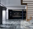 Contemporary architecture with marble flooring, glass walls, staircase with wooden handrails