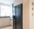 modern design, white cabinets, tiled floor, black refrigerator, faucet, sink, window with blinds