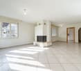 Empty room with fireplace, large windows, white walls, and tiled floor