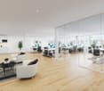 modern office with wooden floors, glass walls, multiple workstations, desks, monitors, a kitchen, couches, table, and chairs